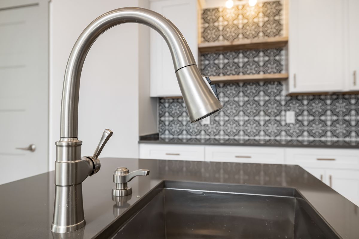 Stainless steel mixer tap above a kitchen sink