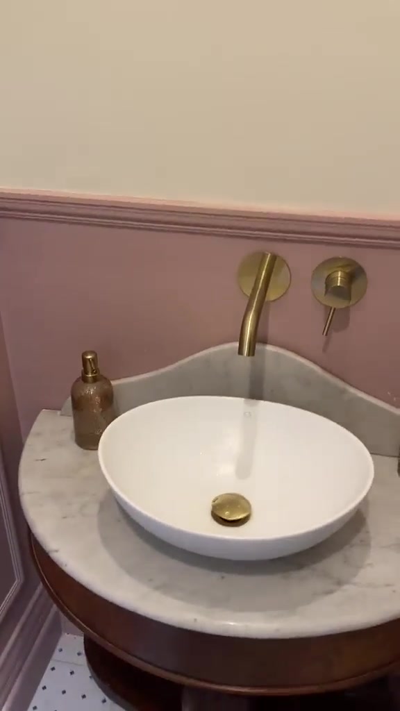 A short walkthrough of a finished cloakroom, showing the toilet, bowl basin and brass-tone wall-mounted tap.